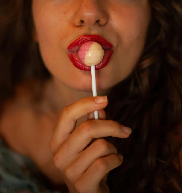 a woman holding a lollipop in her mouth, inspired by Elsa Bleda, trending on pexels, hyperrealism, edible, marshmallow, creamy, 🍸🍋