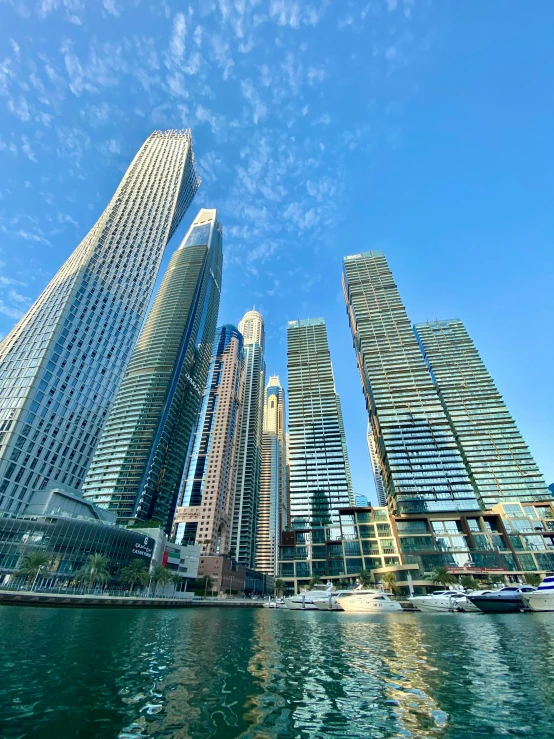 a group of tall buildings next to a body of water, on a super yacht, shot from below, 1km tall, no watermarks