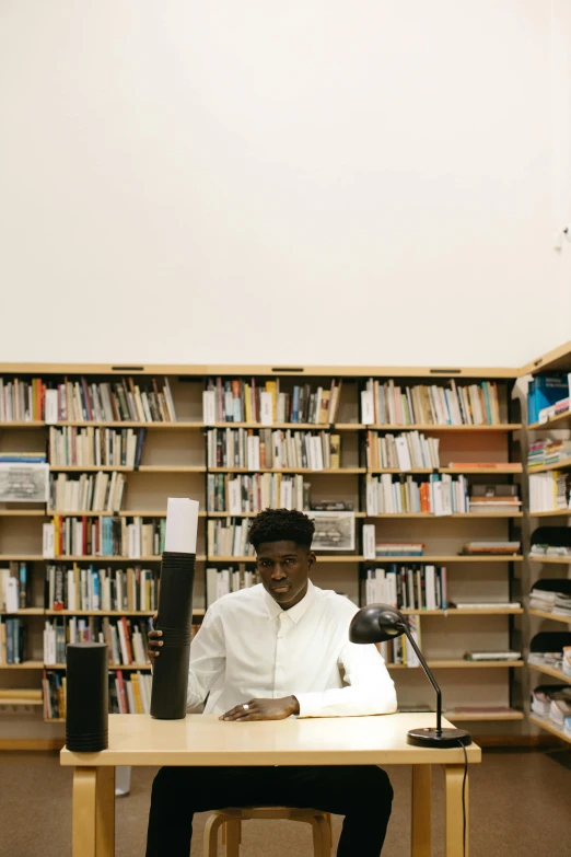 a man sitting at a desk in a library, an album cover, unsplash, black arts movement, with robotic arms, ignant, belgium, thumbnail