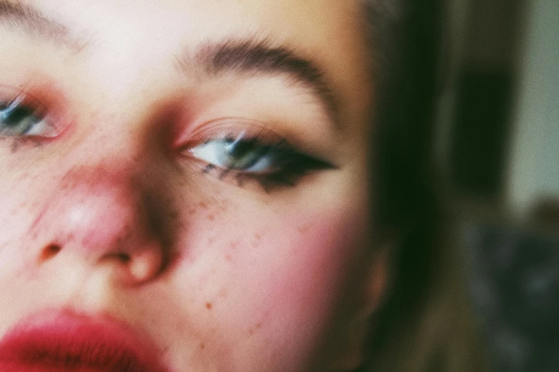 a close up of a woman with freckles on her face, an album cover, inspired by Elsa Bleda, trending on pexels, human face with bright red yes, teenage girl, blurry photo, long pointy pink nose