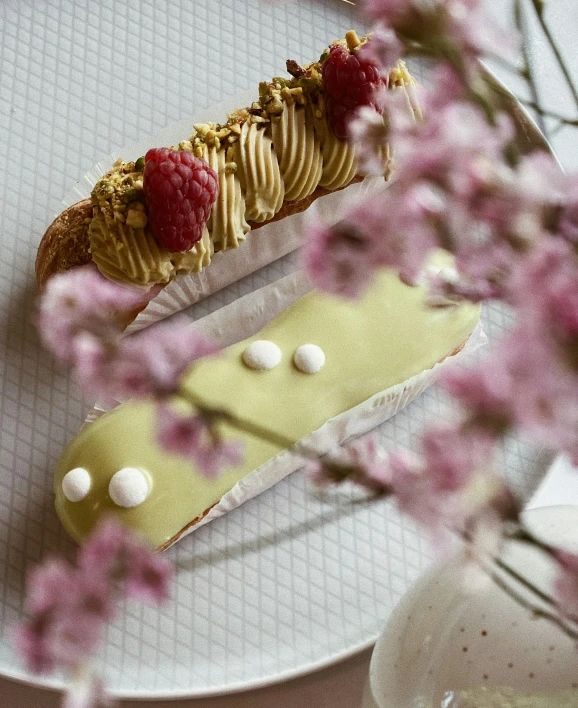 a dessert sitting on top of a white plate, a picture, inspired by Richmond Barthé, unsplash, rococo, sakura bloomimg, the caterpillar, cardboard, olive green and venetian red