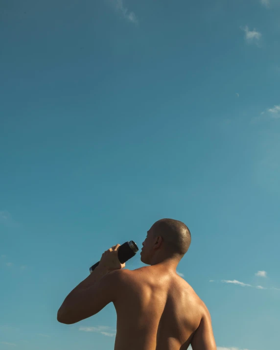 a man standing on top of a sandy beach, looking at the sky, ariel perez, lean man with light tan skin, monocular