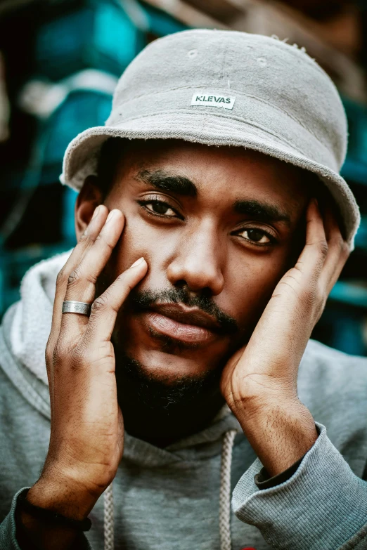 a close up of a person wearing a hat, an album cover, mkbhd, portrait pose, sitting down, baggy eyes