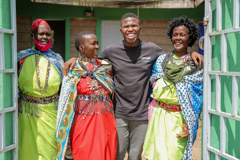 a group of people standing next to each other, a portrait, by Dietmar Damerau, pexels contest winner, wearing an african dress, avatar image, while smiling for a photograph, with village