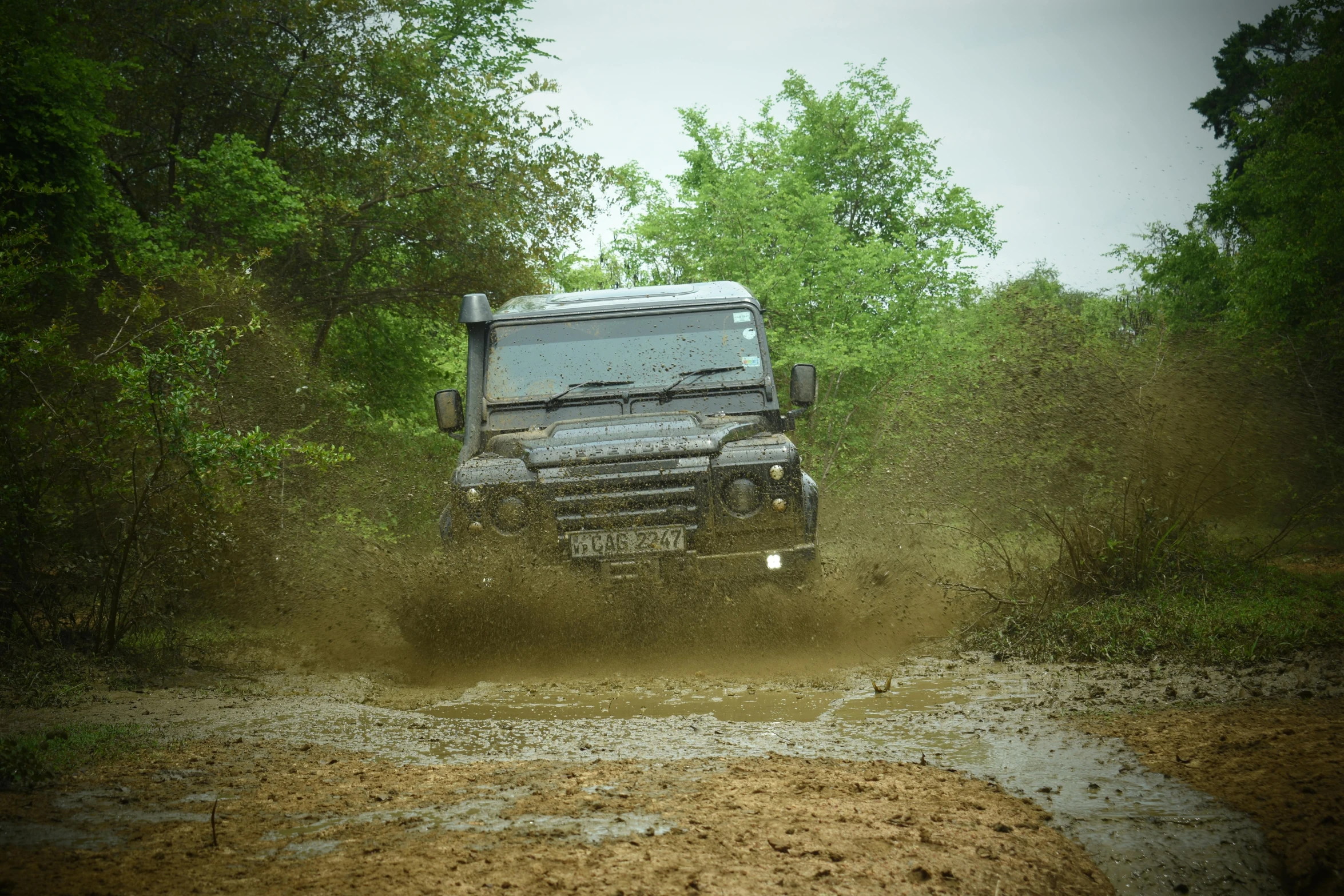 a large truck driving down a muddy road, by Romain brook, land rover defender, sri lanka, drifting, high quality photo