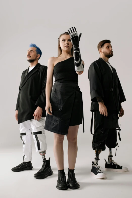 a group of people standing next to each other, an album cover, unsplash, antipodeans, artificial limbs, model is wearing techtical vest, fashion shoot, prostheses