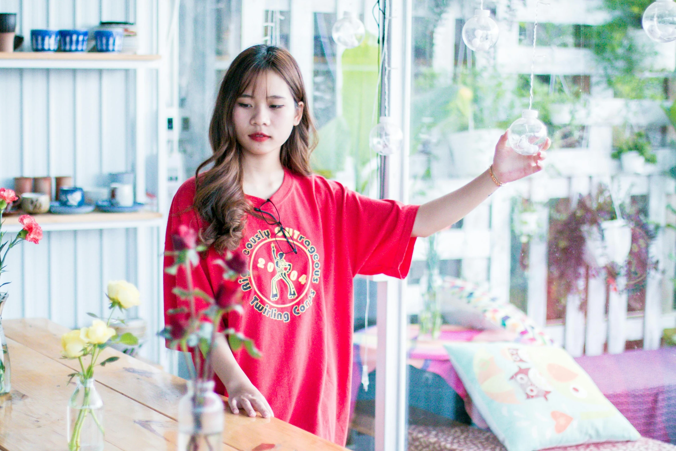 a woman in a red shirt standing in front of a window, pexels contest winner, lalisa manobal, in tshirt, ( waitress ) girl, japanese collection product