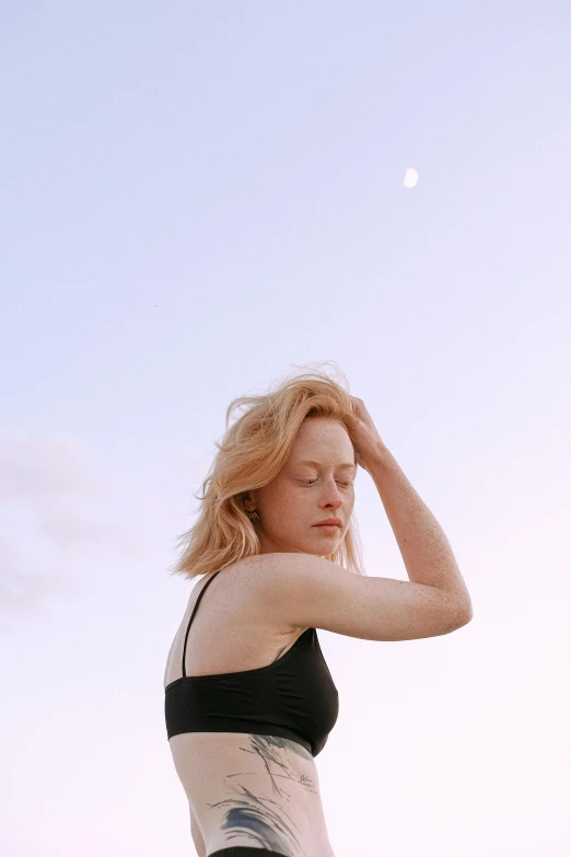 a woman standing on top of a beach next to the ocean, by Carey Morris, trending on pexels, renaissance, portrait of a norse moon goddess, ellie bamber, as she looks up at the ceiling, medium format. soft light