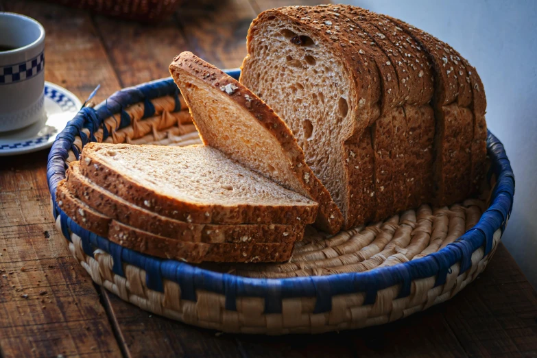 a basket filled with slices of bread next to a cup of coffee, pexels, strong pixar wheat bread warrior, afternoon lighting, rectangle, 4l