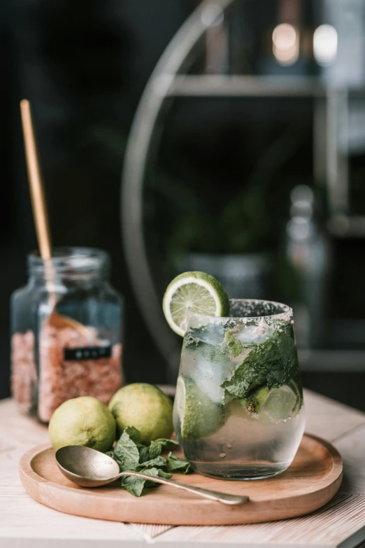 a drink sitting on top of a wooden cutting board, a still life, trending on pexels, mint, in style of lam manh, lime, mixed materials