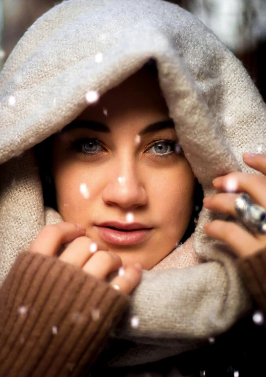 a woman talking on a cell phone in the snow, an album cover, by irakli nadar, trending on pexels, photorealism, beautiful arab woman, eyes, lucy hale, light snowfall