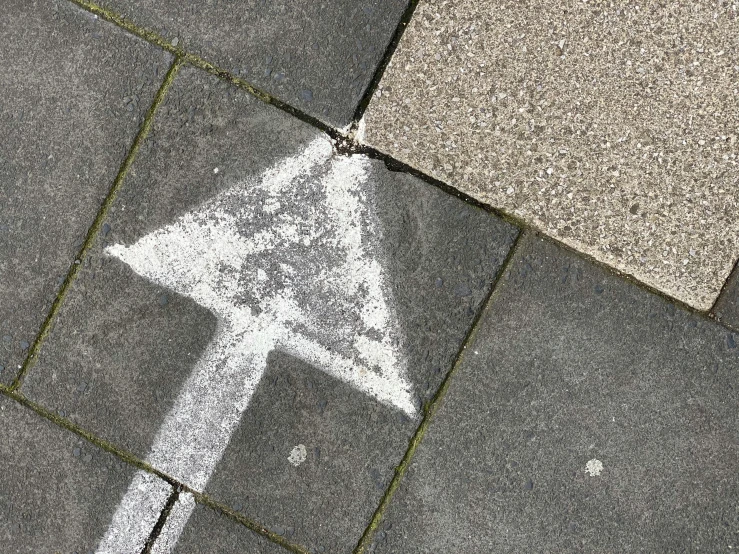 a close up of a street sign on a sidewalk, concrete art, arrow shaped, thumbnail, black chalk, grey