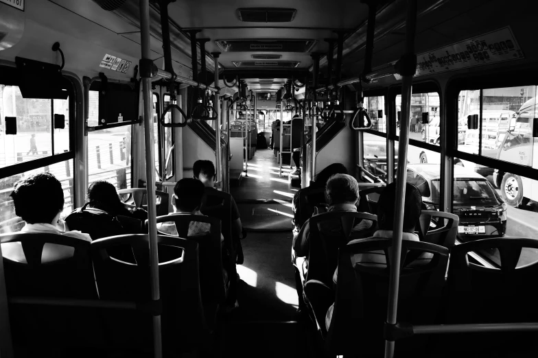 a black and white photo of people on a bus, by Adam Rex, pexels, morning sunlight, carriage full of computers, in the shadows, instagram post