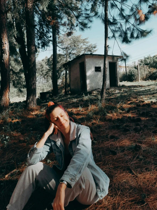 a woman sitting on the ground in the woods, an album cover, unsplash, realism, standing outside a house, in avila pinewood, low quality photo, tourist photo