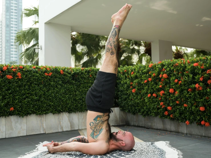 a man is doing a handstand on a rug, arabesque, tattooed, standing on a lotus, danny fox, profile image