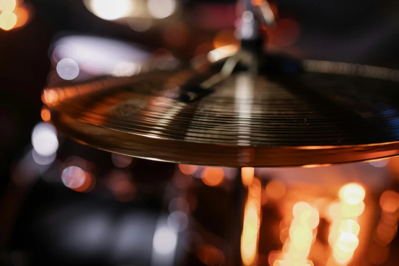 a close up of a drum with lights in the background, an album cover, pexels contest winner, kinetic art, small fire, smooth metal, detail shot, multiple stories