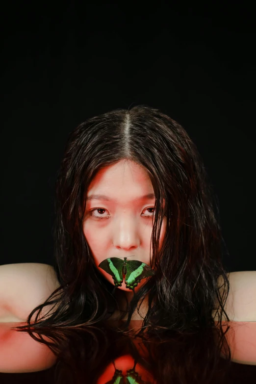 a woman holding a green leaf in front of her face, an album cover, inspired by Taro Yamamoto, butterfly, low quality photo, shibari, made of rubber