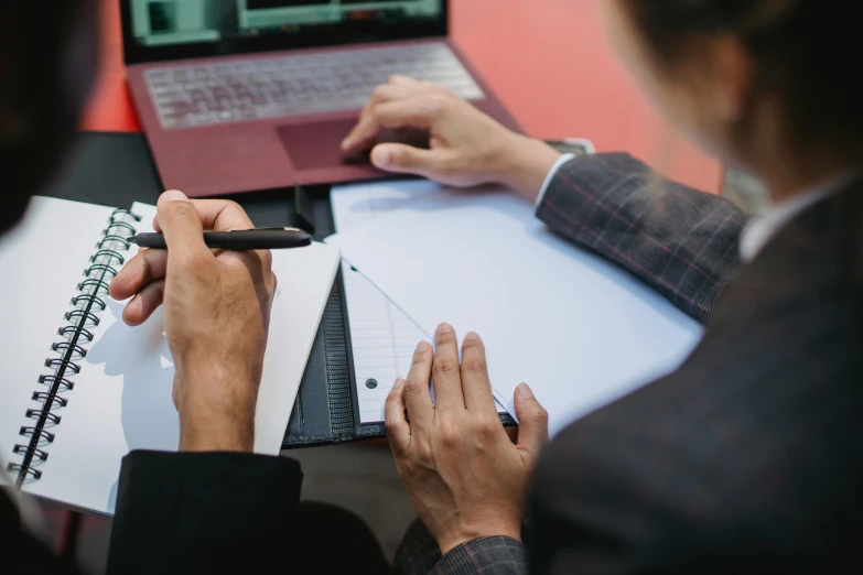 two people sitting at a table with notebooks and a laptop, trending on pexels, bottom angle, holding a clipboard, professional image, ilustration