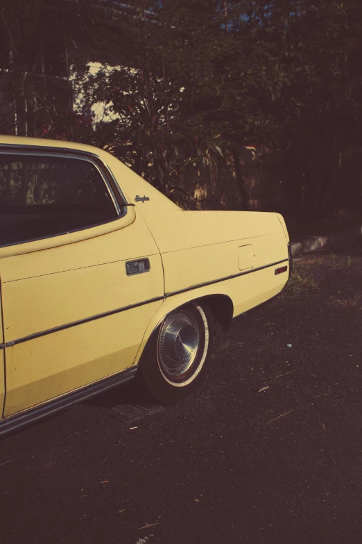 a yellow car parked on the side of the road, an album cover, inspired by Elsa Bleda, unsplash, lowriders, square, old timey, rear-shot