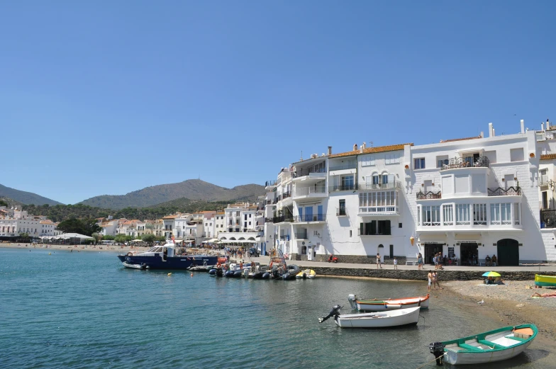 a group of boats sitting on top of a body of water, a picture, white buildings, spanish, kilart, exterior photo