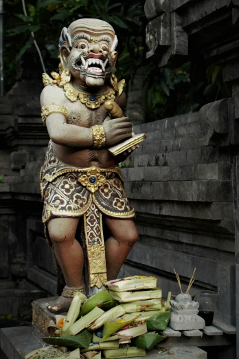 a statue of a man sitting on top of a pile of bananas, a statue, pexels contest winner, sumatraism, reading a book next to a lion, mantis head monster god temple, threatening pose, wearing wooden mask