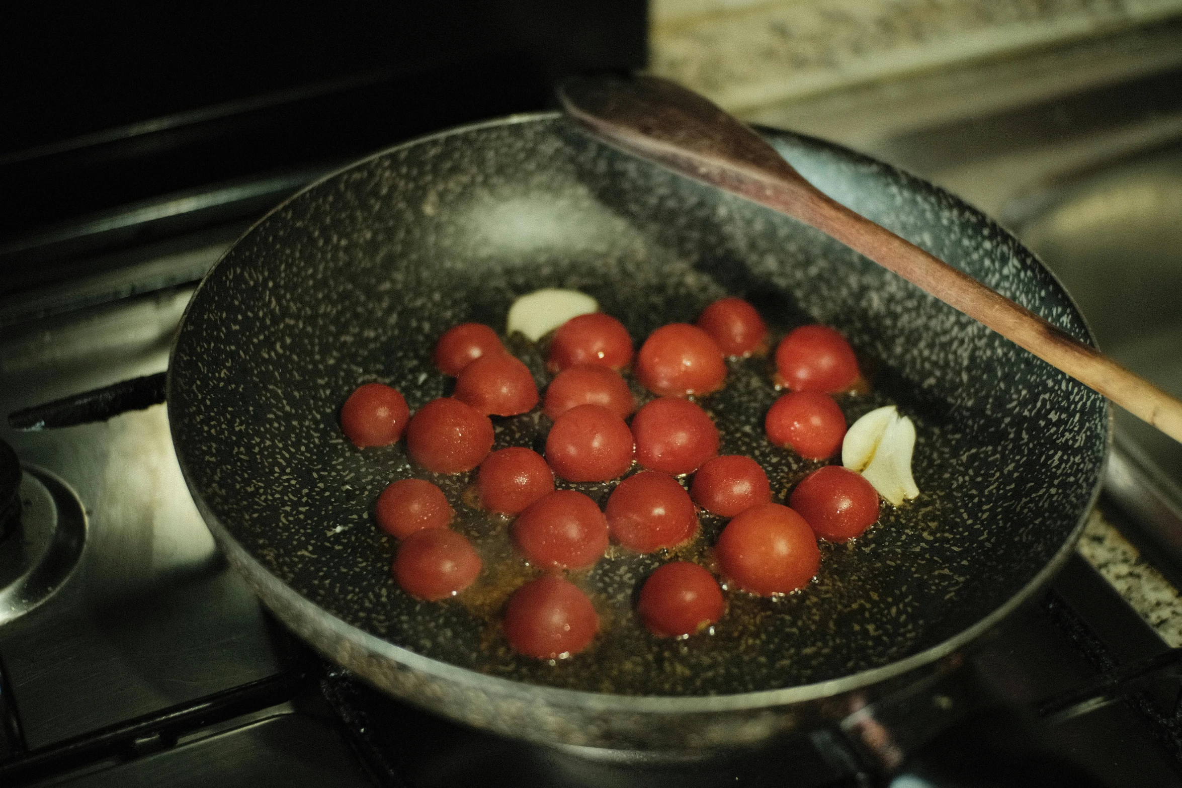 a frying pan filled with tomatoes on top of a stove, by Matt Cavotta, pexels, gif, set photo, leaked image, salad