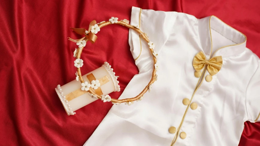a white shirt sitting on top of a red sheet, inspired by Kate Greenaway, gold tiara, various items, gifts, white uniform