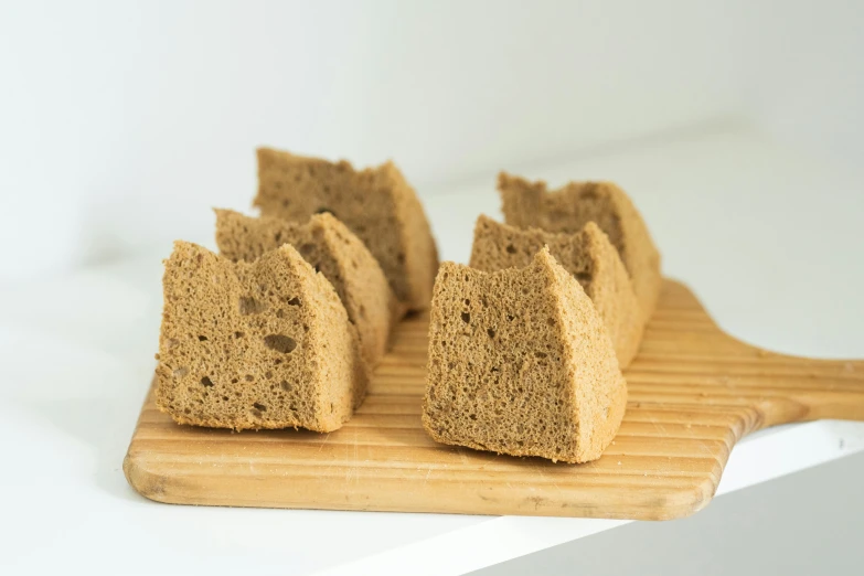 a wooden cutting board topped with slices of bread, mingei, 6 pack, muted brown, cake, sandman