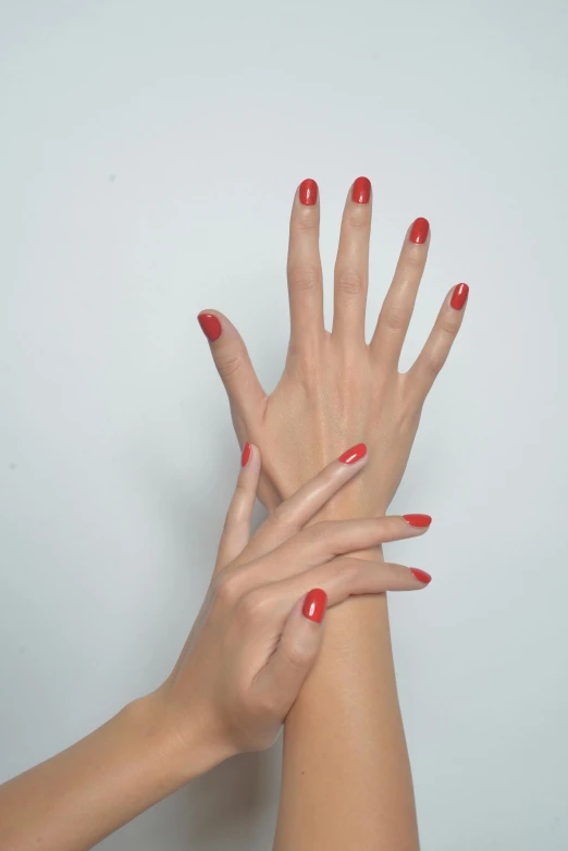 a close up of two hands with red nails, inspired by Marie-Gabrielle Capet, photorealism, silicone skin, medium height, ready to model, colors red