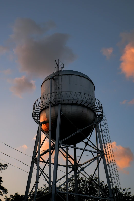 a water tower with a cloudy sky in the background, setting sun, industrial aesthetic, 9/11, 2019 trending photo