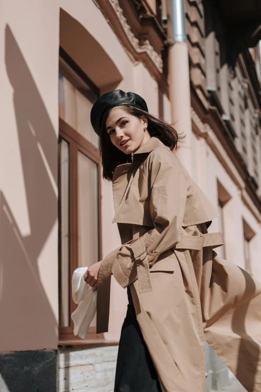 a woman walking down the street in a trench coat, trending on pexels, in style of lam manh, leaning on door, baggy clothing and hat, gif