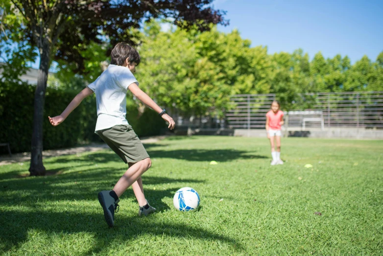 a young boy kicking a soccer ball on a field, unsplash, figuration libre, park on a bright sunny day, summer camp, programming, casual playrix games