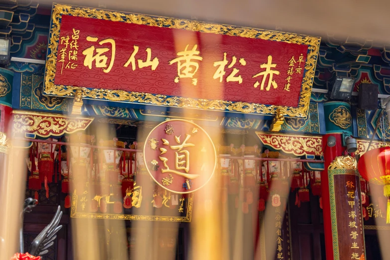 a red sign hanging from the side of a building, a picture, inspired by Gong Xian, pexels contest winner, cloisonnism, an altar of a temple, ethereal beams, yellow lanterns, 王琛