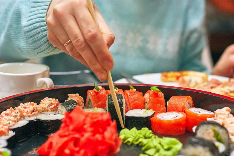 a close up of a plate of food with chopsticks, a picture, by Julia Pishtar, trending on unsplash, ukiyo-e, neanderthal people eating sushi, holding magical kitchen knives, colour corrected, red kimono