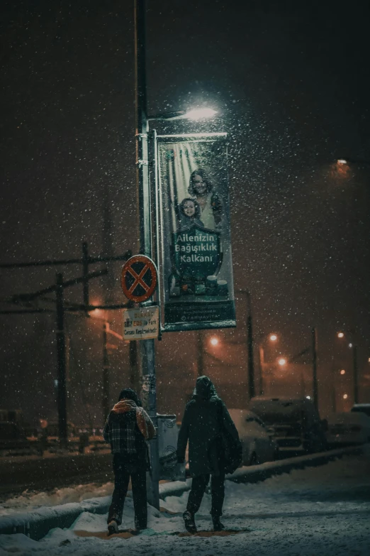 a couple of people that are standing in the snow, a poster, by Adam Marczyński, pexels contest winner, socialist realism, dark city bus stop, commercial banner, in a suburb, under street lamp