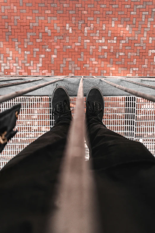 a person standing on top of a metal bridge, pexels contest winner, realism, black shoes, stood in a cell, high angle vertical, looking upwards