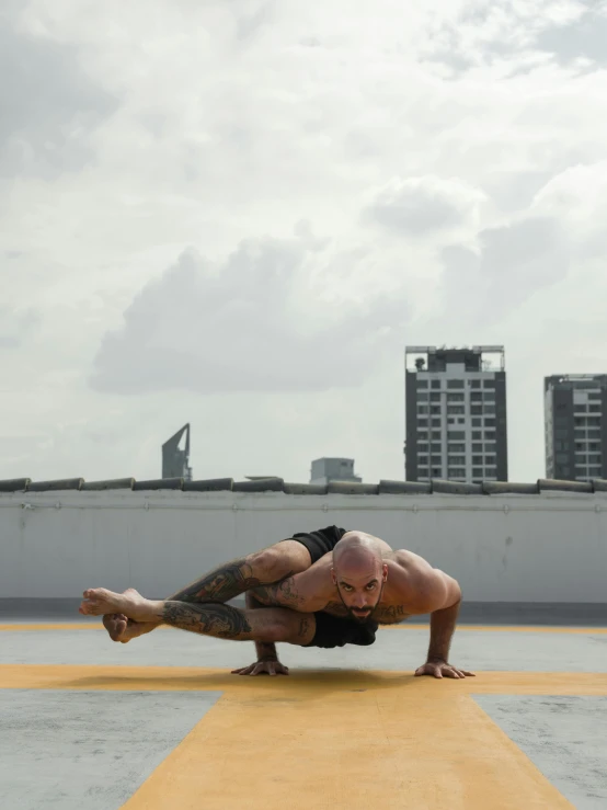 a man doing a handstand on top of a building, a tattoo, inspired by Graham Forsythe, pexels contest winner, singapore ( 2 0 1 8 ), yoga meditation pose, lower half of his body is snake, 8 5 mm photograph