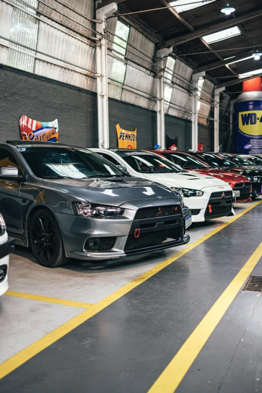 a group of cars parked next to each other in a garage, wētā fx, fantastic vendor interior, official store photo, p. a. works