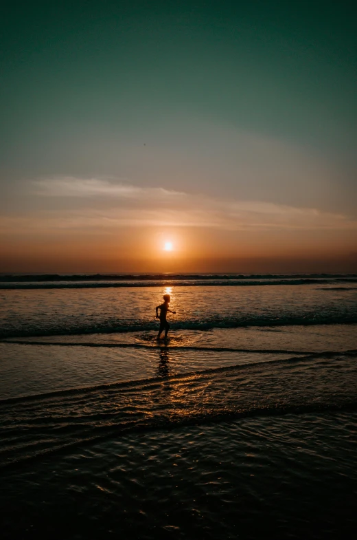 a person riding a surfboard on top of a beach, by Jan Tengnagel, pexels contest winner, sunsetting color, bali, standing in shallow water, minimalist