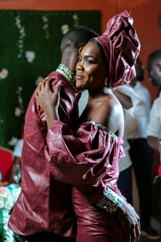 a couple of people that are hugging each other, an album cover, by Chinwe Chukwuogo-Roy, pexels, happening, ornately dressed, brown, celebration, film movie still