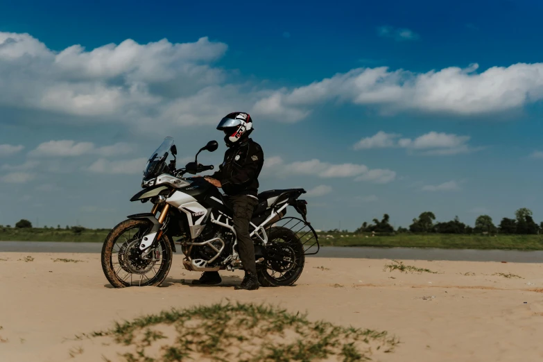 a man riding a motorcycle on top of a sandy beach, dirt road, avatar image, panzer, explore
