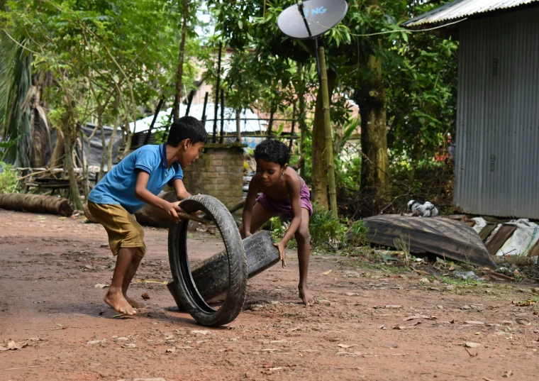 two children playing with a tire on a dirt road, pexels contest winner, hurufiyya, assamese, at home, animation, 15081959 21121991 01012000 4k