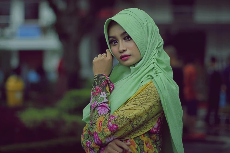 a woman in a hijab talking on a cell phone, a colorized photo, by Basuki Abdullah, pexels contest winner, hurufiyya, light green tone beautiful face, square, wearing an ornate outfit, beautiful girlfriend