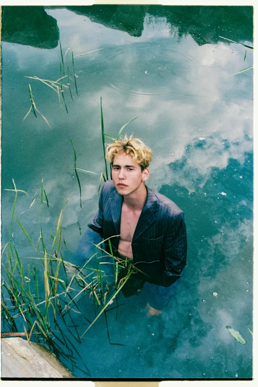 a man standing in a body of water, an album cover, trending on pexels, caspar david, with soft bushes, film portrait, model posing