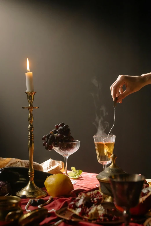 a person lighting a candle on a table, a still life, inspired by Georges de La Tour, renaissance, liquid smoke twisting, epicurious, 2019 trending photo, medieval photograph