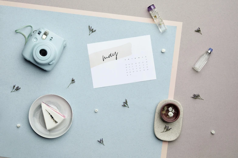 a calendar sitting on top of a table next to a cup of coffee, a picture, by Julia Pishtar, trending on pexels, minimalism, paper quilling, lavender blush, scattered props, selfie photo