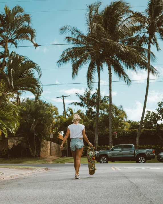 a person walking down a street with a skateboard, by Maggie Hamilton, unsplash contest winner, tropical setting, dressed in a top and shorts, maui, sydney sweeney