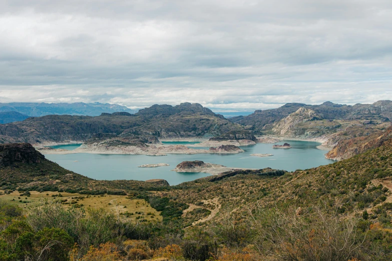 a large body of water sitting on top of a lush green hillside, by William Berra, pexels contest winner, in chuquicamata, panoramic view, dessert, 2 5 6 x 2 5 6 pixels