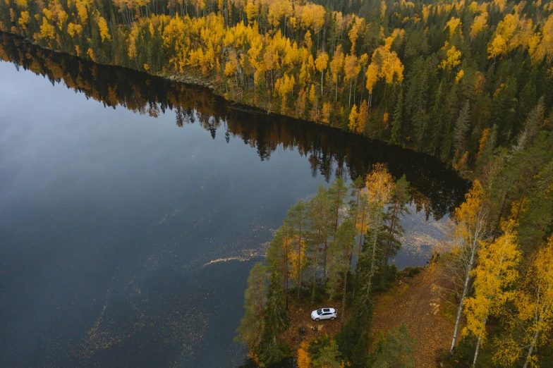 an aerial view of a lake surrounded by trees, by Jaakko Mattila, pexels contest winner, hurufiyya, car shot, mid fall, thumbnail, sitting in front of a lake