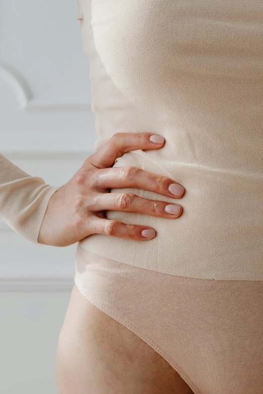 a woman with her hands on her stomach, trending on pexels, made of lab tissue, detailed product image, light tan, spasms